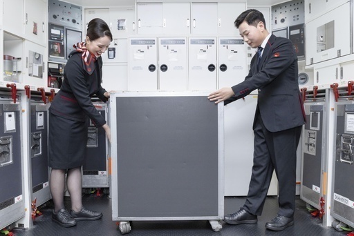 スニーカーを履いてカートを押す客室乗務員＝13日、東京都大田区（共同）