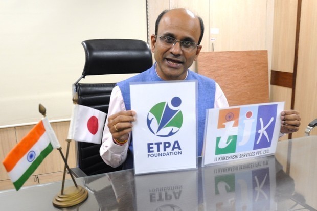 ＥＴＰＡのロゴ（左）を手に写真撮影に応じるサンジェイ・パンダさん＝11月、インドの首都ニューデリー（ＮＮＡ撮影）