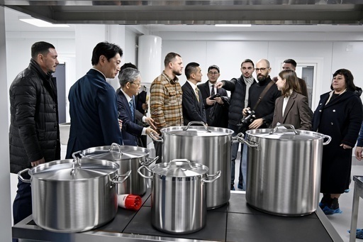 ウクライナ首都キーウ近郊のデミディフ村で、完成した給食センターを見学する披露式の出席者＝３日（共同）