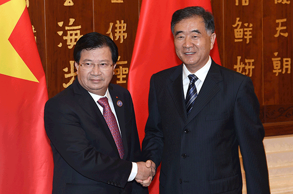 第４回中国・南アジア博覧会に出席するため訪中したベトナムのチン・ディン・ズン副首相（左）と握手を交わす中国の汪洋副首相＝６月12日、中国・昆明（新華社）