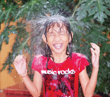 雨どいシャワーを楽しむ子ども（ニョニュム提供）