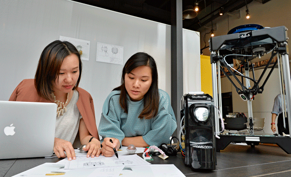 カフェで談笑する若い女性――。ではなく、彼女らは製品のデザイナー。傍らには３Ｄプリンターがあり、設計から試作まで、このデスク１卓で作業する。香港の新しい工業の形だ＝香港科学園（ＮＮＡ撮影）