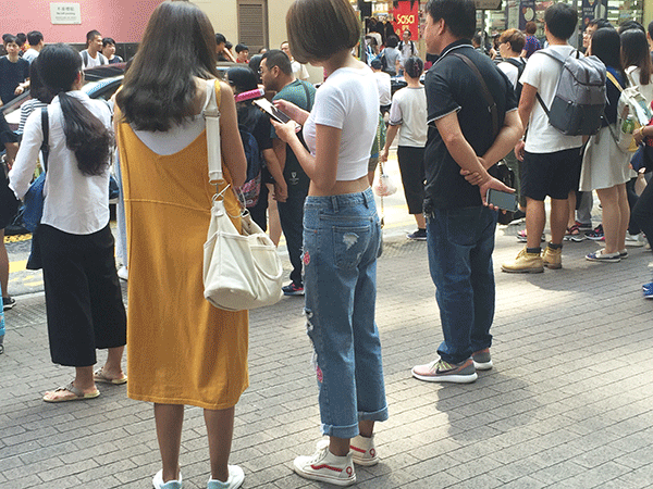香港の街中の若者スタイル。シンプルで着やすいものを重視するため、スニーカーを履く人が多い（筆者撮影） 