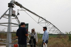 視察に訪れた農家にセンターピボット方式のかんがいシステムについて説明するヌアンラオーン氏（中央）＝サケオ県（ＮＮＡ撮影）