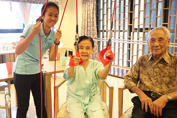 介護士（左）と一緒にレッドコードで運動するマユリーさん（中）とサガさん＝10月、バンコク（ＮＮＡ撮影）