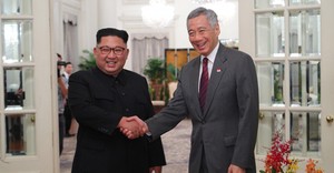 米朝首脳会談でシンガポールを訪問した北朝鮮の金正恩朝鮮労働党委員長（左）と握手するリー・シェンロン首相。今年は後継者選びの動きが加速した（シンガポール首相府提供）