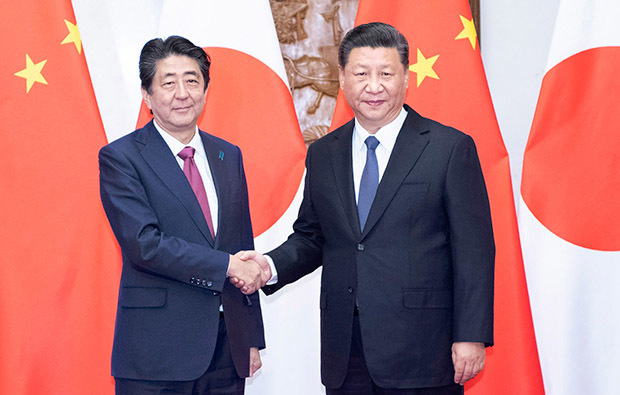 習近平国家主席（右）と握手を交わす安倍晋三首相＝10月26日、北京（新華社）