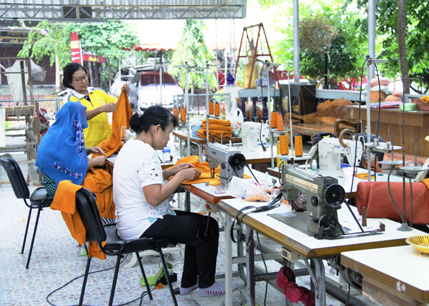 ペットボトルをリサイクルして作った再生繊維で袈裟を縫う女性たち＝７月24日、タイ・サムットプラカン県（ＮＮＡ撮影）