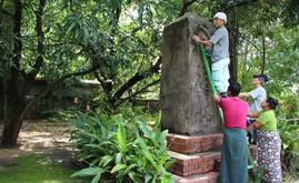 72年前に建立された鎮魂の碑をはしごに上って修復する湊さん＝19日、ヤンゴン（ＮＮＡ）
