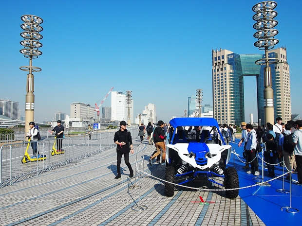 東京モーターショーの２会場を結ぶ1.5キロのオープンロード。ヤマハのオフロード四輪ビーグルの脇を試乗の電動キックボードが走る（ＮＮＡ撮影）