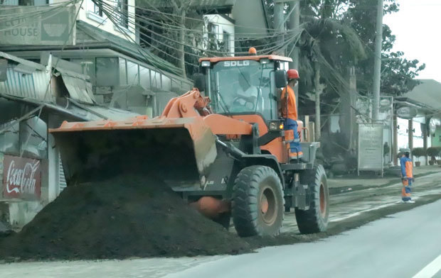 道路に積もった灰を除去する作業員たち＝14日、カビテ州タガイタイ（ＮＮＡ撮影）