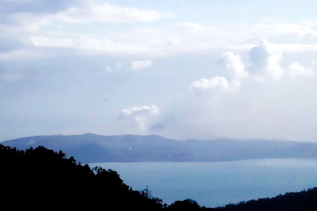 噴煙を上げるタール火山＝14日、カビテ州タガイタイ（ＮＮＡ撮影）