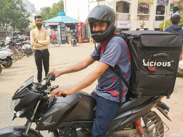 バイクで生鮮品を輸送するリシャスの配達員＝インド・グルガオン（ＮＮＡ撮影）