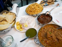 「カリーム」のテーブル。ムガル宮廷風料理で使われる食材の筆頭、マトンの肉を粗くひいたキーマ（右下）は薄焼きにしたロティ（左）と共に。カルダモン、シナモンなどのスパイスをふんだんに使った米料理ビリヤーニ（上）もぜいたくな味わい