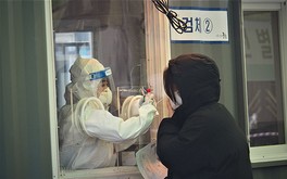 ソウル駅前に設置された新型コロナのウイルス検査場で、検体の採取に応じる女性＝2021年２月９日、韓国・ソウル（ＮＮＡ撮影）

