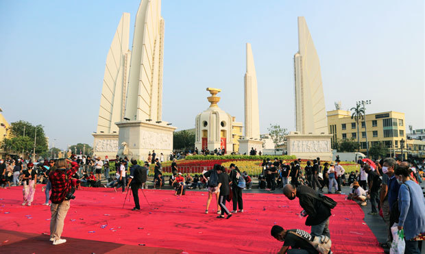 民主記念塔で開かれた反体制デモで、巨大な布に不敬罪の廃止などの要求を書き込む参加者たち＝13日、タイ・バンコク（ＮＮＡ撮影）