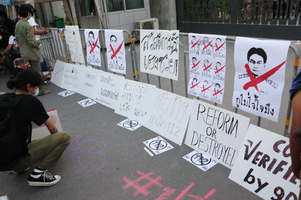 不信任決議案が否決されたことを受け反体制派グループは、審議の対象となった10閣僚の似顔絵にバツ印を付けた紙などを国会前のフェンスに貼り付けて抗議した＝20日、タイ・バンコク（ＮＮＡ撮影）