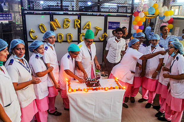新型コロナワクチン接種が累計10億回に達したことを祝う医療従事者＝10月21日、インド・西部ムンバイ（ＰＴＩ）