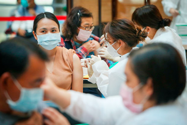 新型コロナウイルスのワクチンを接種する市民＝12月、台北（中央通信社）