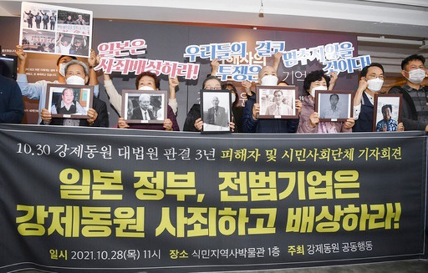 ソウル市で開かれた記者会見でシュプレヒコールを上げる元徴用工らの支援団体メンバーら（共同）