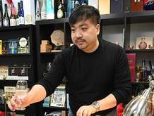 香港に到着した「ねっか」の日本酒をテイスティングする楊さん（ＮＮＡ撮影）