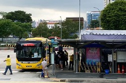 マレーシア行きのＶＴＬ専用バスに乗り込む人々＝22日、シンガポール中心部（ＮＮＡ撮影）