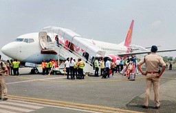 インド東部ビハール州パトナのジャイ・プラカシュ・ナラヤン国際空港に緊急着陸したスパイスジェットの航空機から降りる乗客ら＝19日（ＰＴＩ）