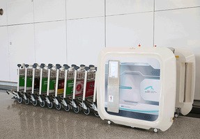 香港国際空港に納入した殺菌設備。並んだカートに沿って装置が動いて殺菌するため作業負担がほとんどない（ウシオ香港提供）