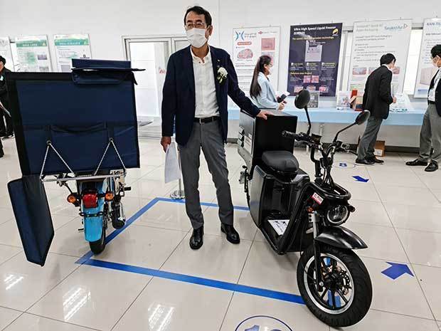 保冷機を乗せた電動バイクの試作品を紹介するフルハーフ・マハジャックの最所社長＝16日、タイ・バンコク（ＮＮＡ撮影）