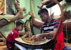 ミャンマー・ヤンゴンの工房で「サウン・ガウ」を作るミンナインさん（右）とアウンミンカン君＝８月（共同）