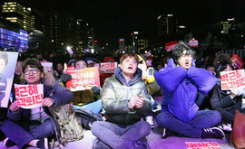 弾劾案可決の直後に光化門で開かれた退陣要求集会では、可決を喜ぶ参加者から笑顔も見られた＝９日、韓国・ソウル（ＮＮＡ撮影）