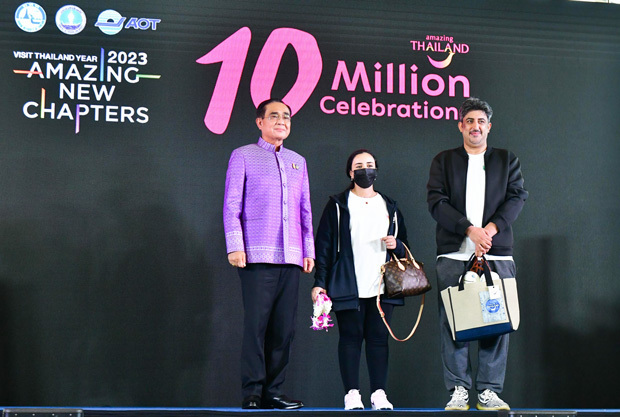 スワンナプーム国際空港で2022年の1,000万人目の入国者を自ら出迎えるプラユット首相（左）＝12月（タイ政府提供）