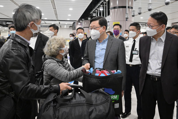 香港と中国本土の隔離なし往来がようやく再開。陸路検問所を通る市民に声をかける李行政長官（中央）＝８日、落馬洲（香港政府提供）