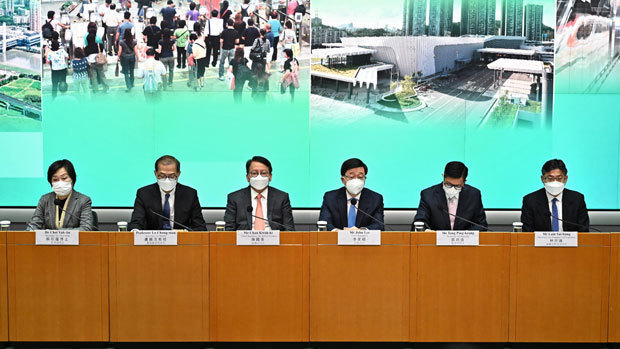 李行政長官（右３）ら高官が３日に会見を開き、本土との往来正常化を発表した（香港政府提供）