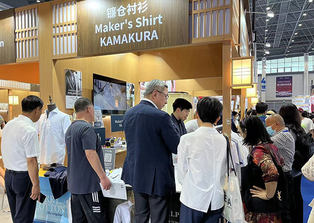 消費品博に出展したメーカーズシャツ鎌倉のブースには開催初日から人があふれた＝４月、海口市