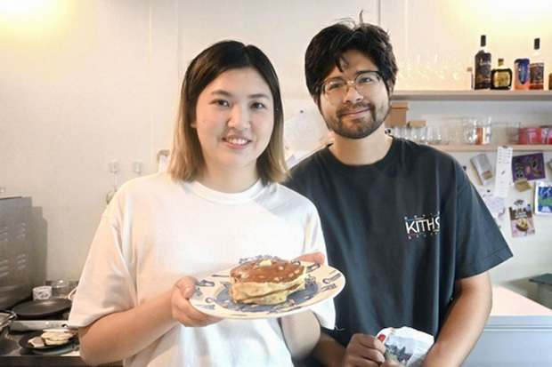 大麻カフェを経営するピタさん（右）と、大麻成分入りのパンケーキを持つ交際相手＝10日、バンコク（共同）