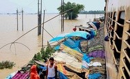 インド北東部アッサム州で大規模な洪水が発生し、住民が線路沿いの仮設テントに避難した＝26日（ＰＴＩ）