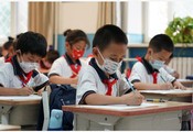 北京市では27日から、市内の小中学校と高校で通学が再開した。マスク着用で授業を受ける児童ら（新華社）