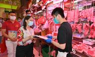 返還25周年を記念して公設市場を巡回する食品環境衛生署の黄副署長（左の女性）ら＝29日（香港政府提供）